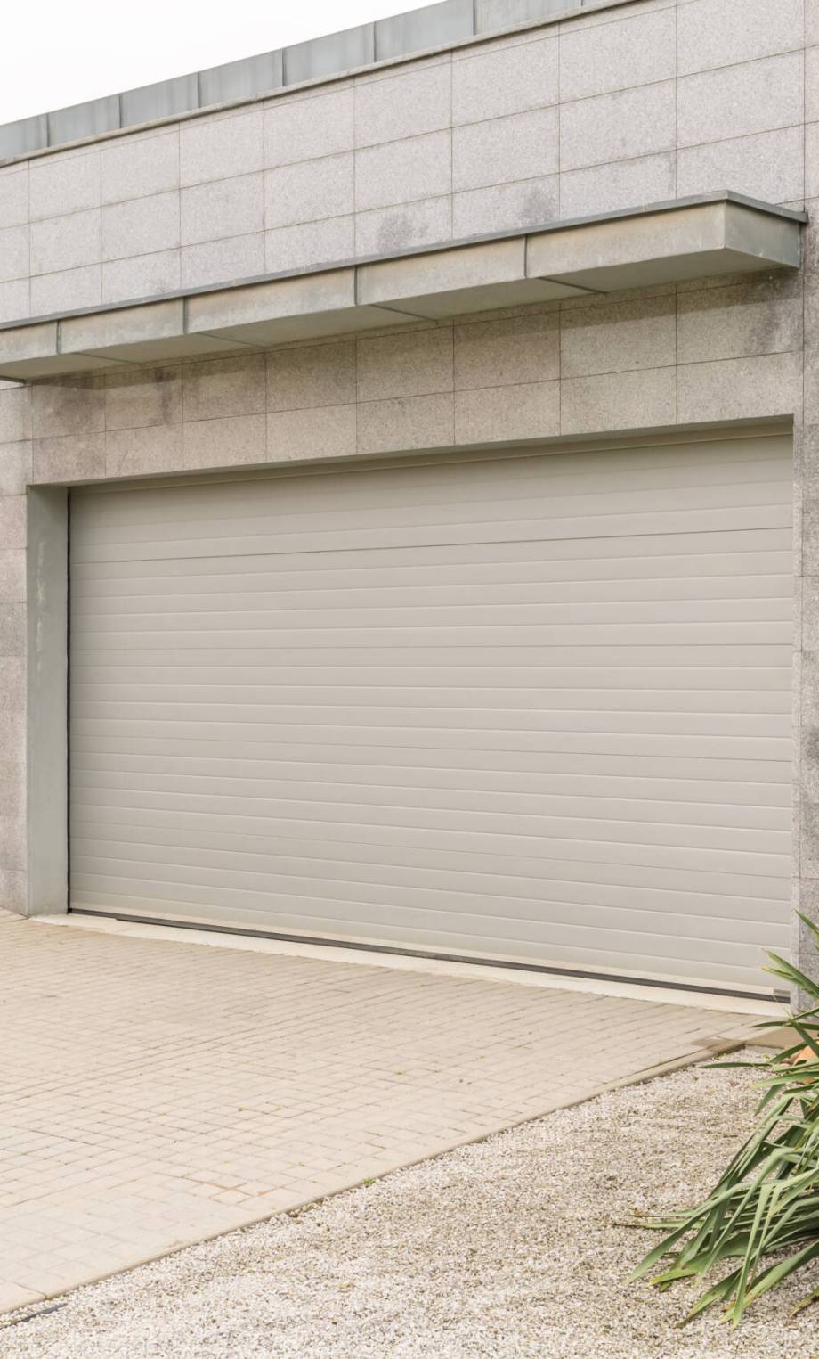 Big grey house with a drive way and a parking garage