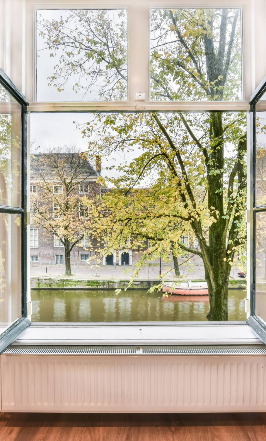 Open window with a view of the canal with trees