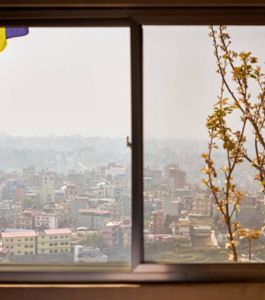 View of Kathmandu from hotel window through urban haze with lot of low rise buildings, cityscape creating an ethereal atmosphere in mountain air, Kathmandu air pollution
